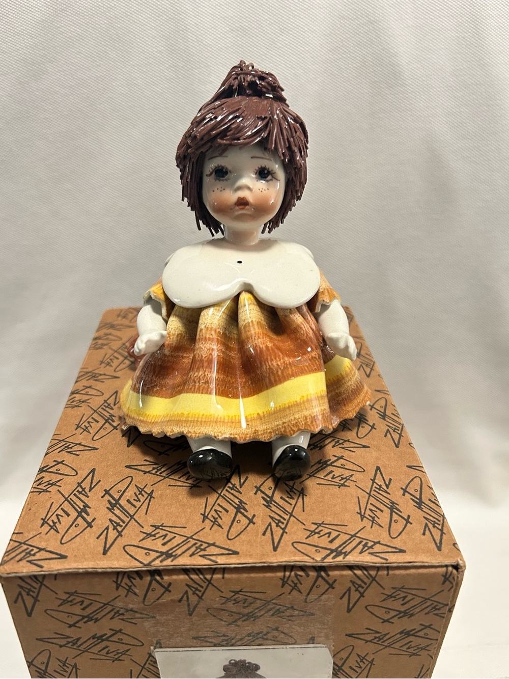 lino zampiva Porcelain Doll Figurine with Brown Hair and Yellow-Orange Dress